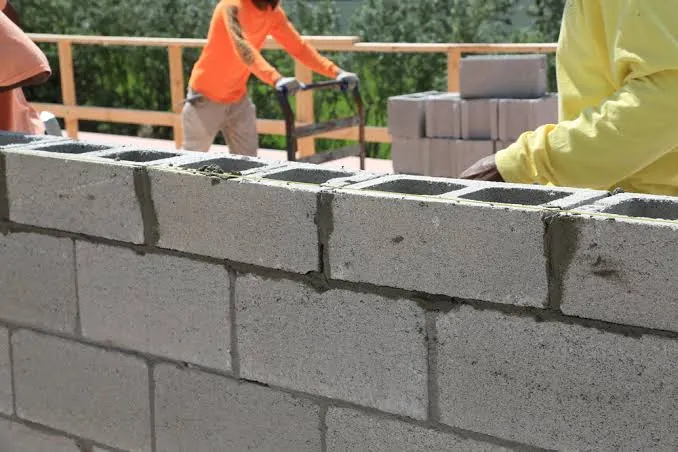 Pedreiros erguendo parede de alvenaria estrutural com blocos de concreto Fiorotto